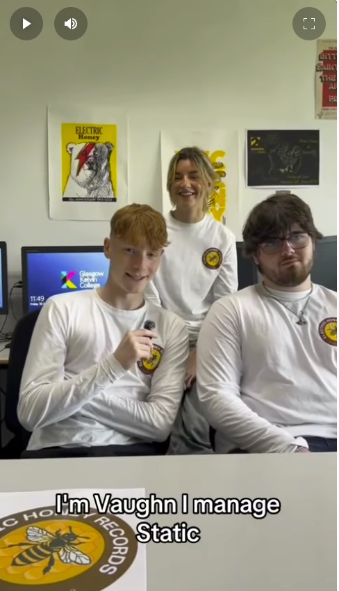 Three Glasgow Kelvin College Music Business students wearing Electric Honey Records shirts, smiling during a group video interview in a classroom.
