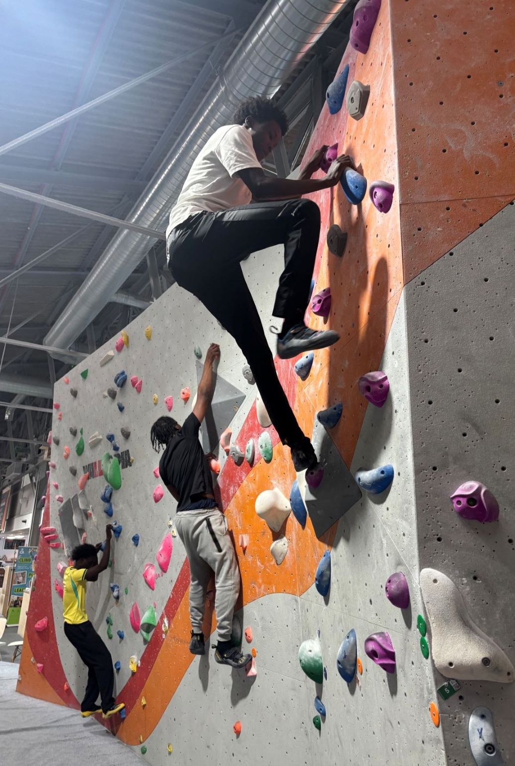 Student climbing an indoor bouldering wall at the Climbing Academy in Glasgow.