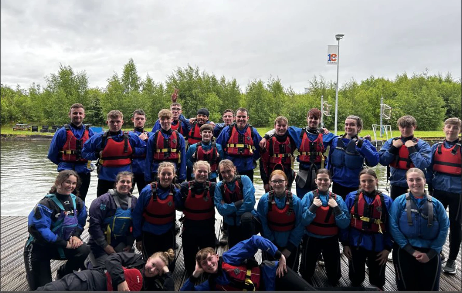 Group of Glasgow Kelvin College students wearing wetsuits and life jackets posing together at Pinkston Watersports Centre after an outdoor activity session.  Group of Glasgow Kelvin College students wearing wetsuits and life jackets posing together at Pinkston Watersports Centre after an outdoor activity session.