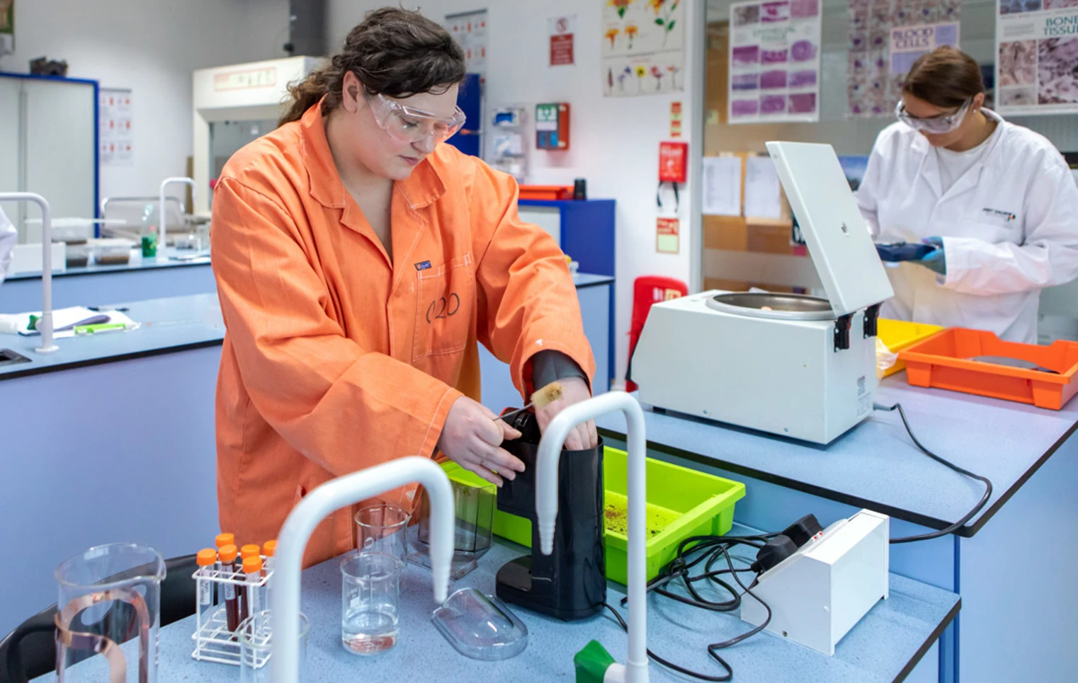 Student using lab equipment with centrifuge in science lab during practical session Student using lab equipment with centrifuge in science lab during practical session