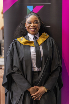 A smiling Glasgow Kelvin College graduate poses in their graduation gown during Graduation 2025.