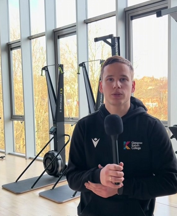 Sport student speaking into a microphone in a gym at Glasgow Kelvin College.