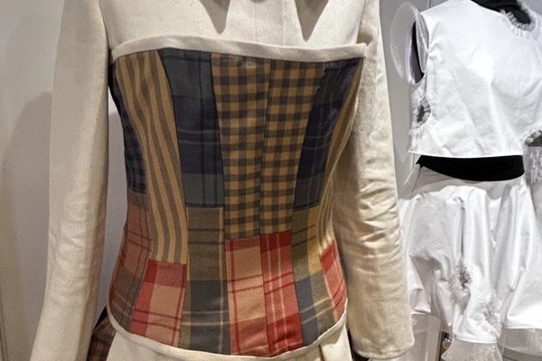 A cream jacket with a colourful tartan patchwork bodice and layered ruffle skirt, part of an upcycled fashion design on display at Craftex 2025 A cream jacket with a colourful tartan patchwork bodice and layered ruffle skirt, part of an upcycled fashion design on display at Craftex 2025