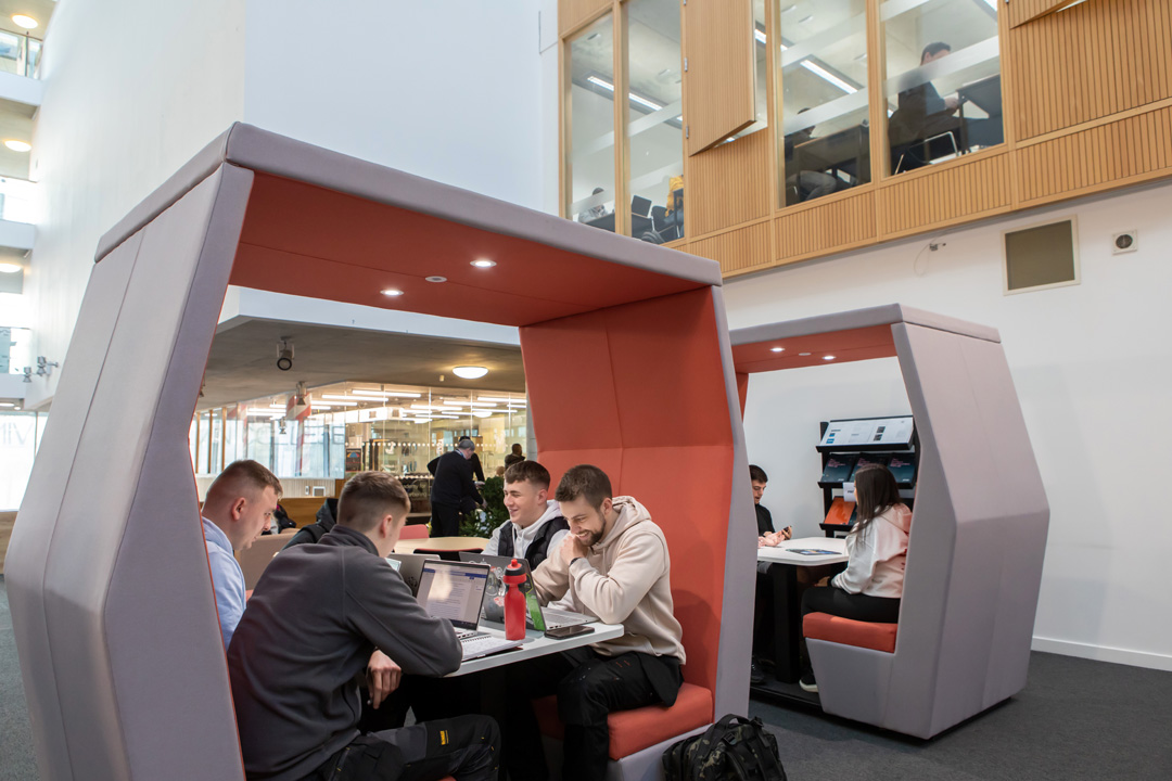 Students working together in modern study pods at Glasgow Kelvin College’s Springburn campus, using laptops and notebooks in a collaborative space.