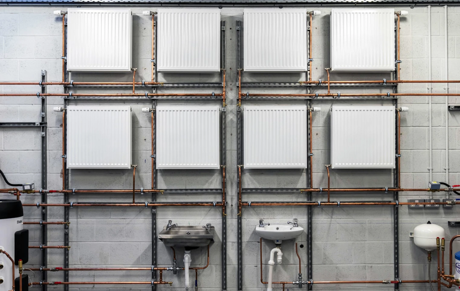 Wall-mounted radiators, sinks, and copper pipework arranged in a plumbing training workshop at Glasgow Kelvin College Wall-mounted radiators, sinks, and copper pipework arranged in a plumbing training workshop at Glasgow Kelvin College
