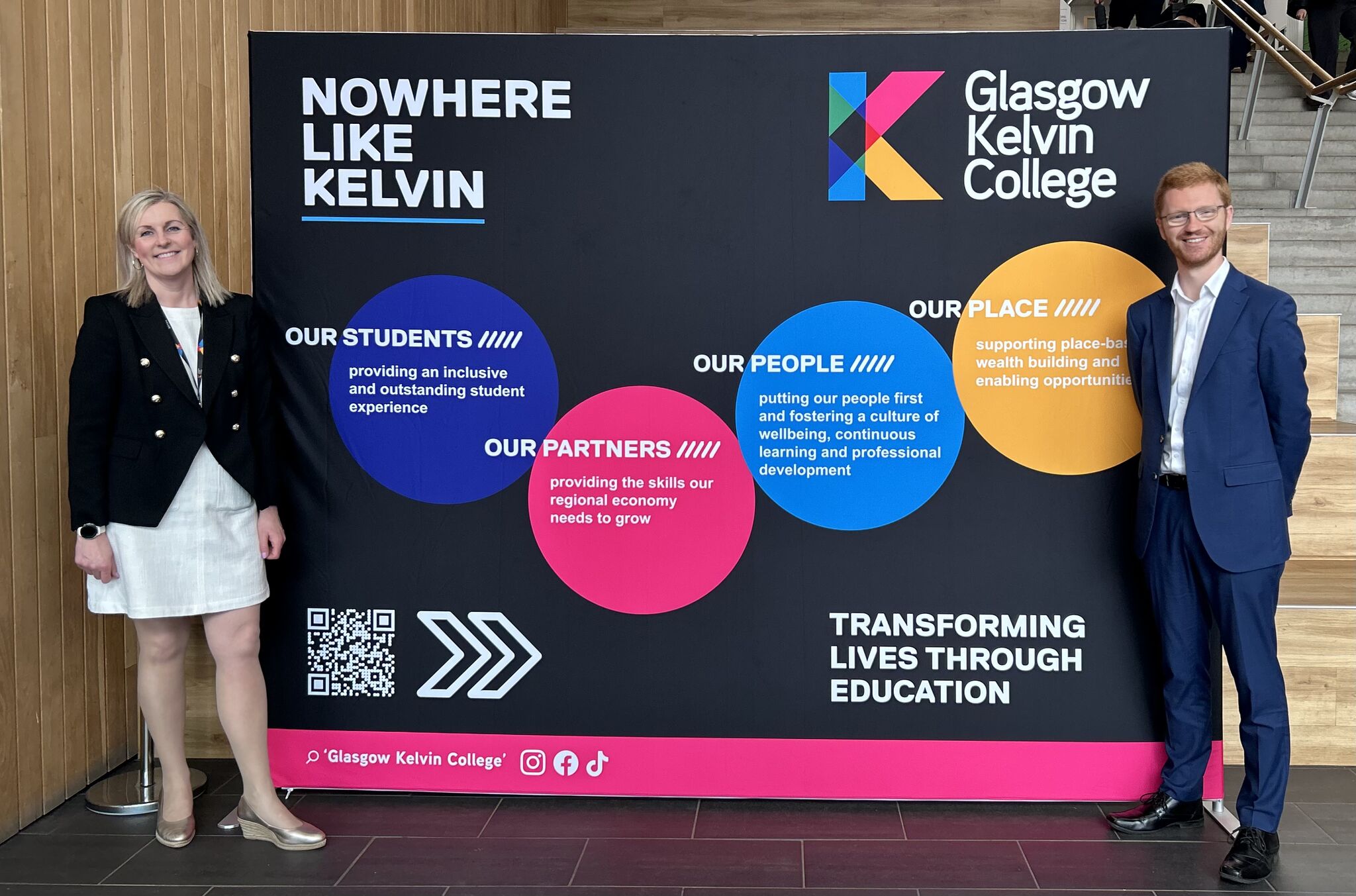 Visitors standing beside Glasgow Kelvin College display board highlighting students, partners and community impact.