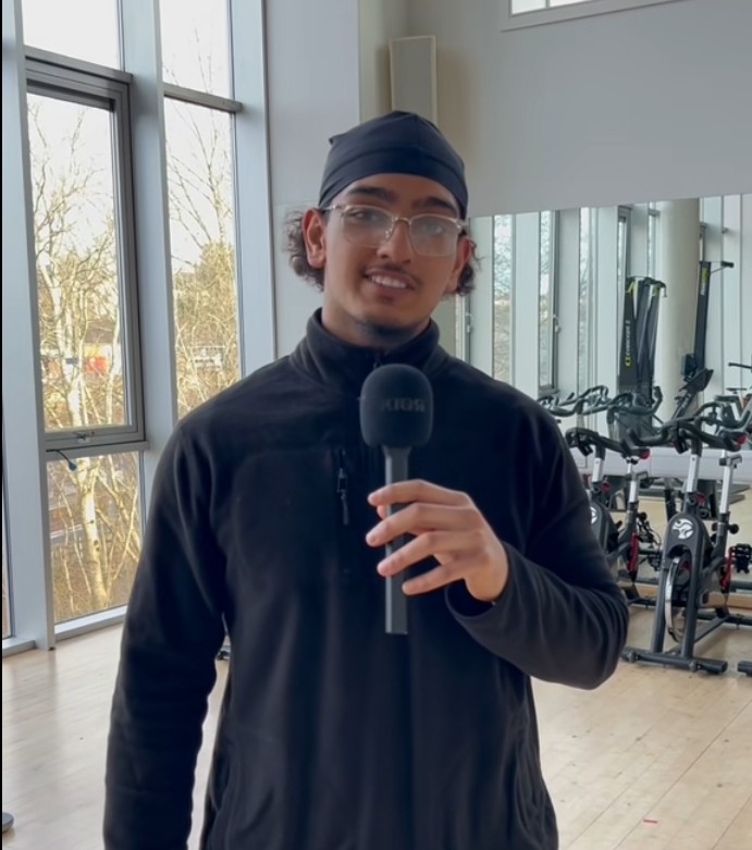 Sport and Fitness student holding microphone and speaking in gym facility at Glasgow Kelvin College.