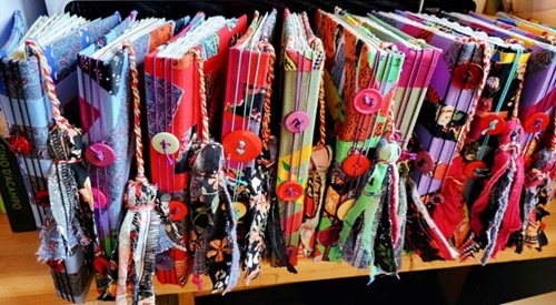 Handmade notebooks created from recycled textiles displayed on a table at Glasgow Kelvin College sustainability project